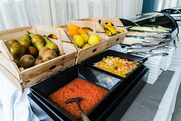 una mesa de buffet con cajas de frutas y salsas