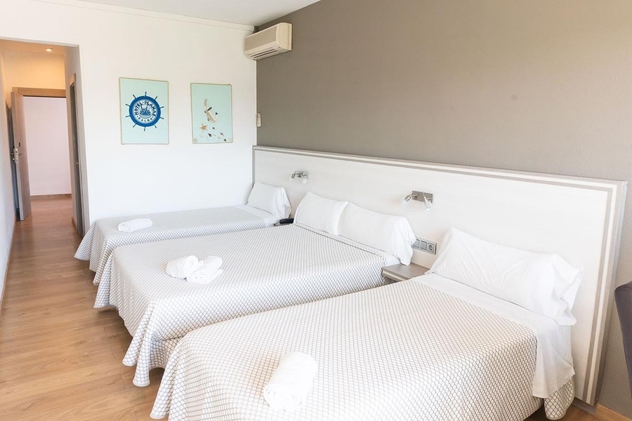 a hotel room with three beds and a steering wheel on the wall