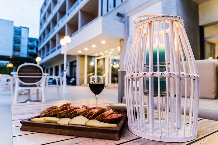 una mesa de madera con una bandeja de comida y un vaso de vino