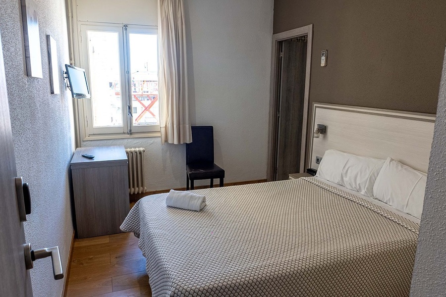 a hotel room with a bed and a television