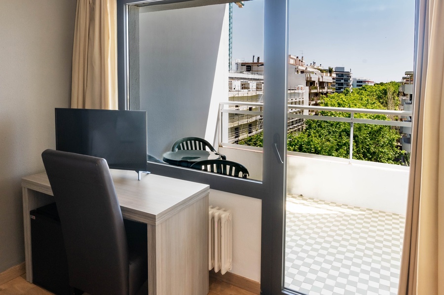 a sliding glass door opens to a balcony overlooking a city