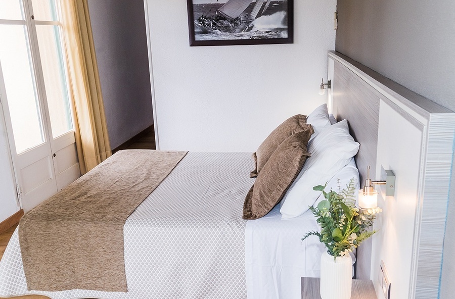 a picture of a sailboat hangs above a bed