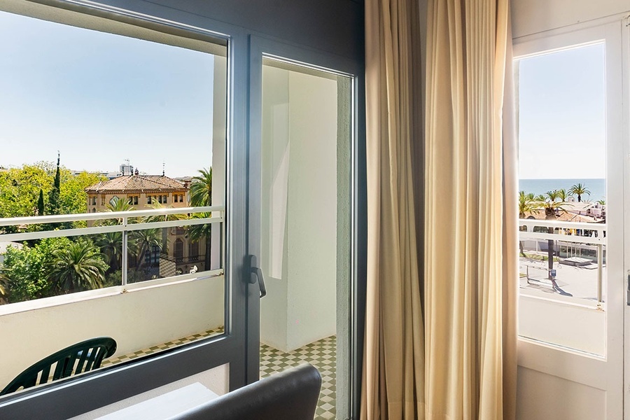 a hotel room with a balcony and a view of the ocean