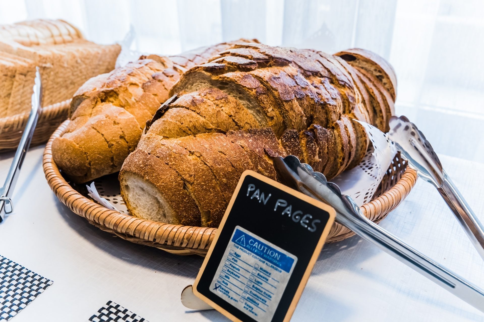 pan en una canasta de mimbre junto a una señal de precaución
