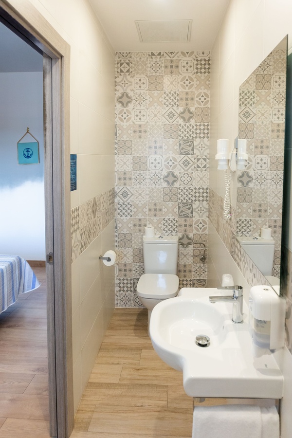 a bathroom with a toilet and a sink with a sign on the wall that says 