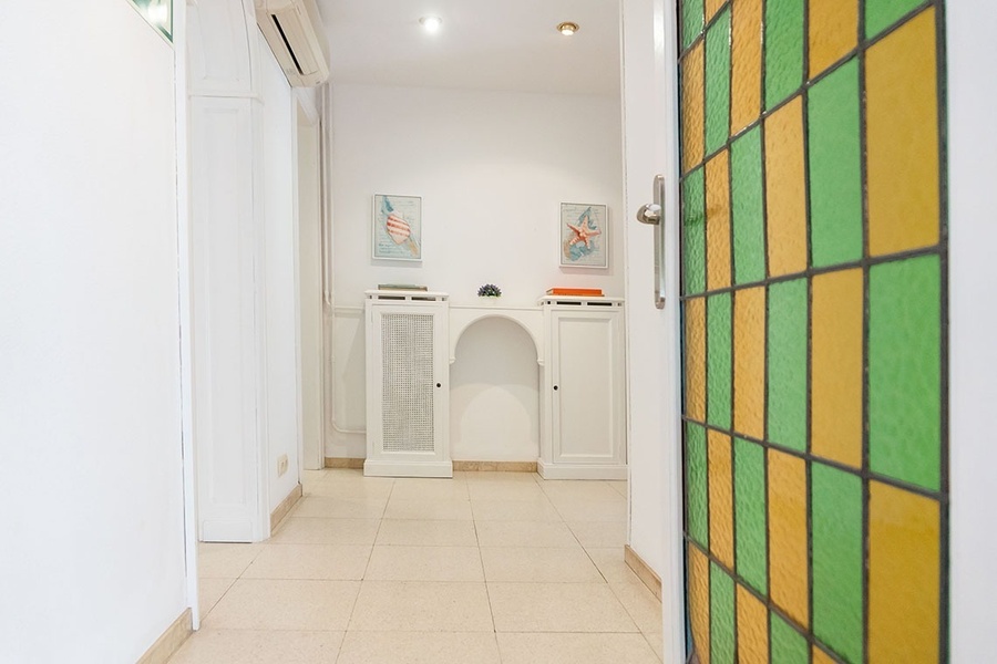 a hallway with a green and yellow stained glass door
