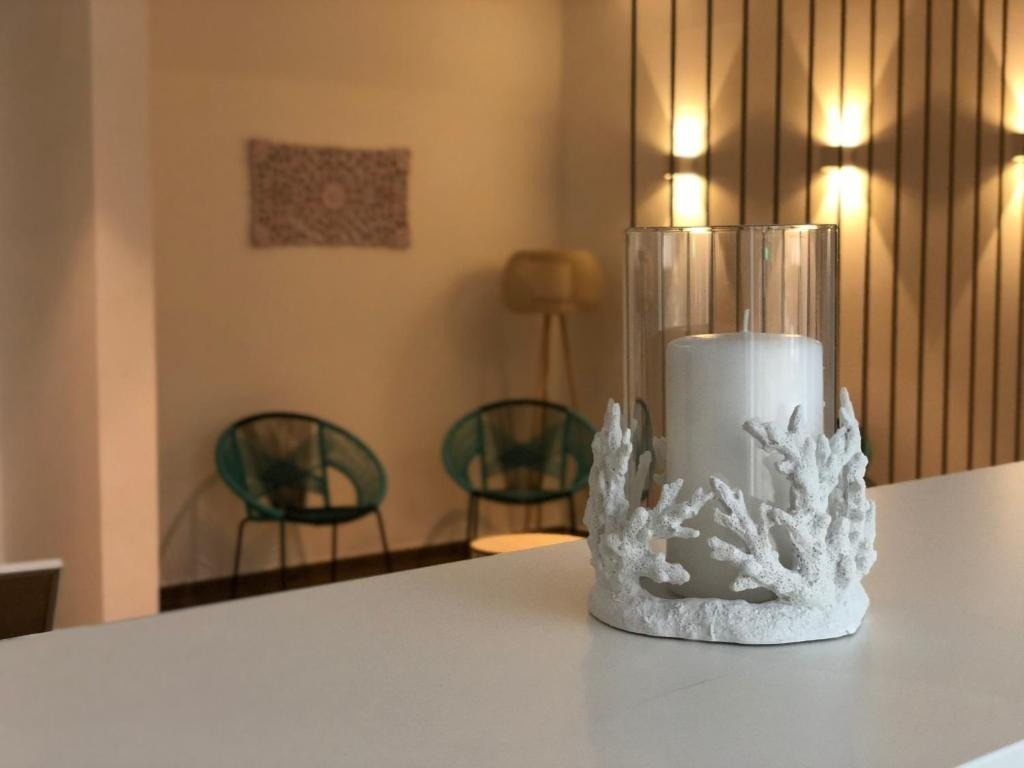 una vela blanca se sienta en un candelabro hecho de corales