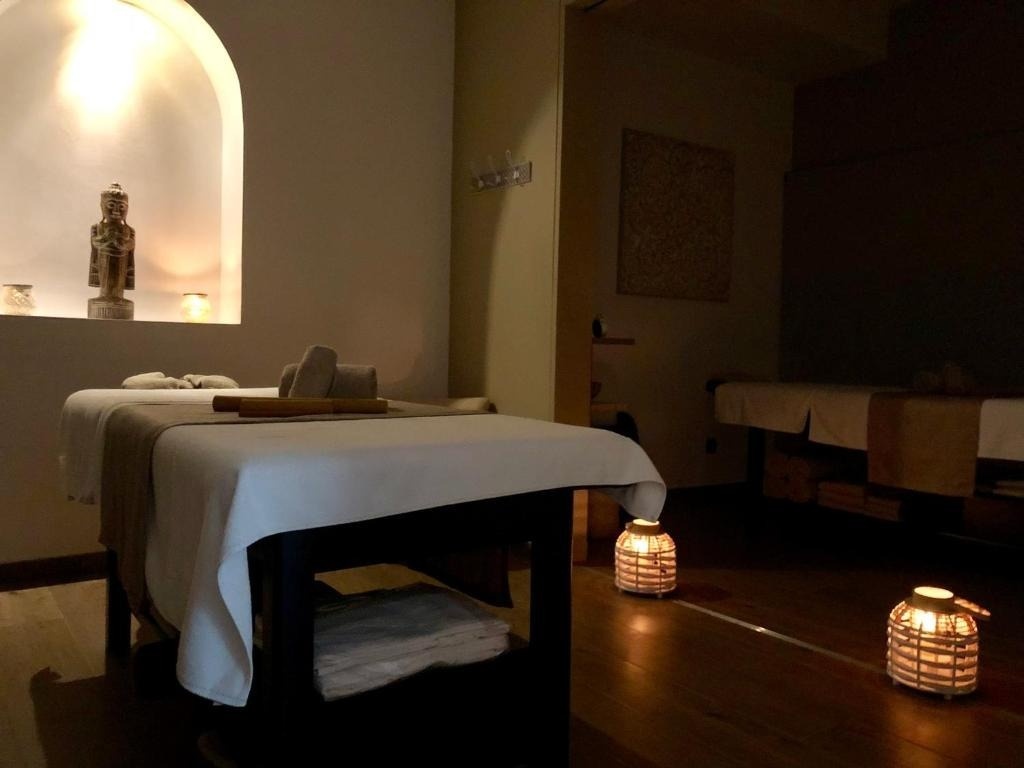 una mesa de masaje con toallas y velas en una habitación oscura