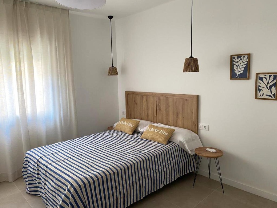 Hotel Planas double room with blue and white striped bedding and two decorative pillows.
