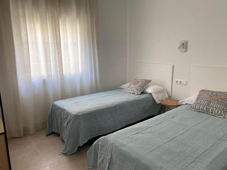 Twin room with separate beds and curtains at Hotel Planas.
