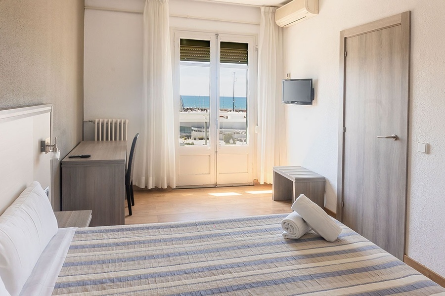 a hotel room with a striped bed and a flat screen tv