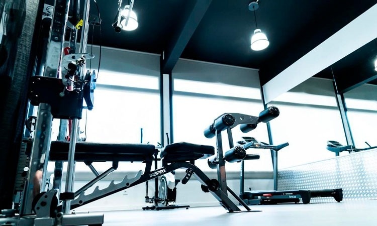 un gimnasio con un banco y una cinta de correr