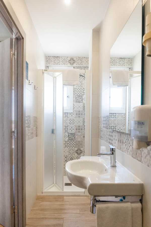 a bathroom with a sink a mirror and a soap dispenser