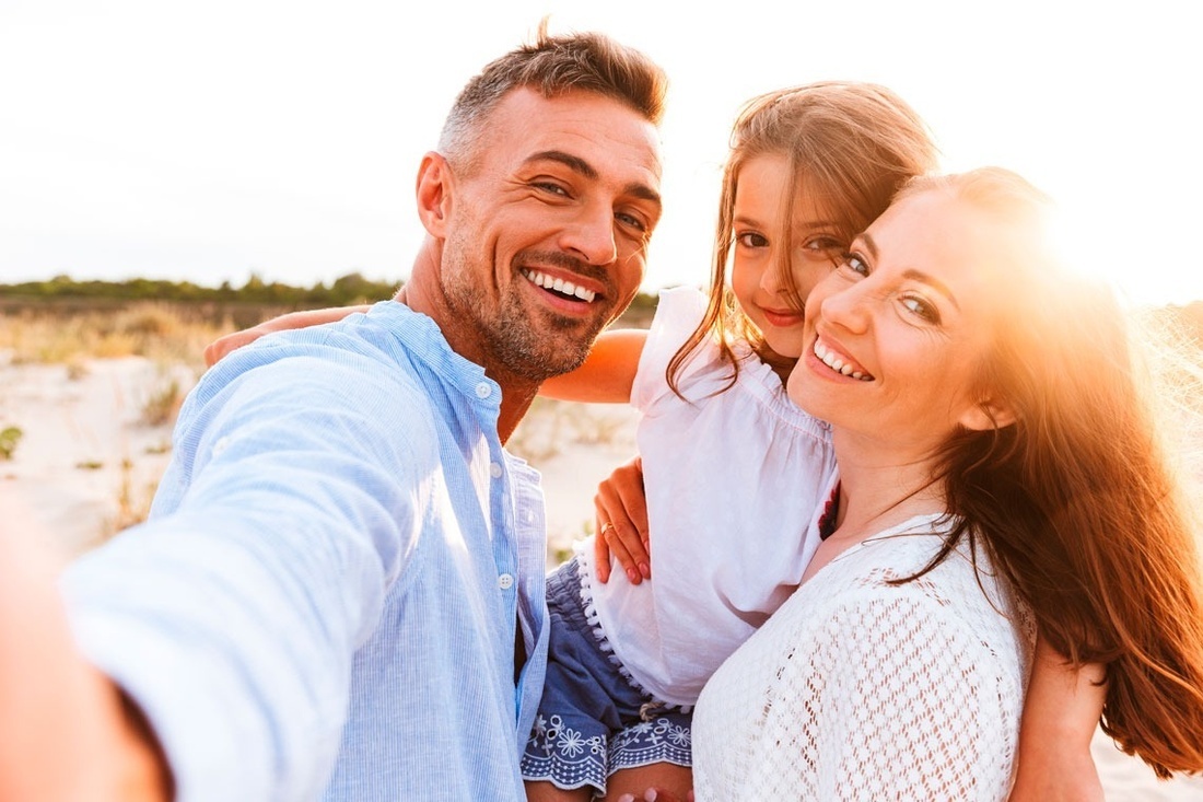 a man and woman holding a little girl on their shoulders