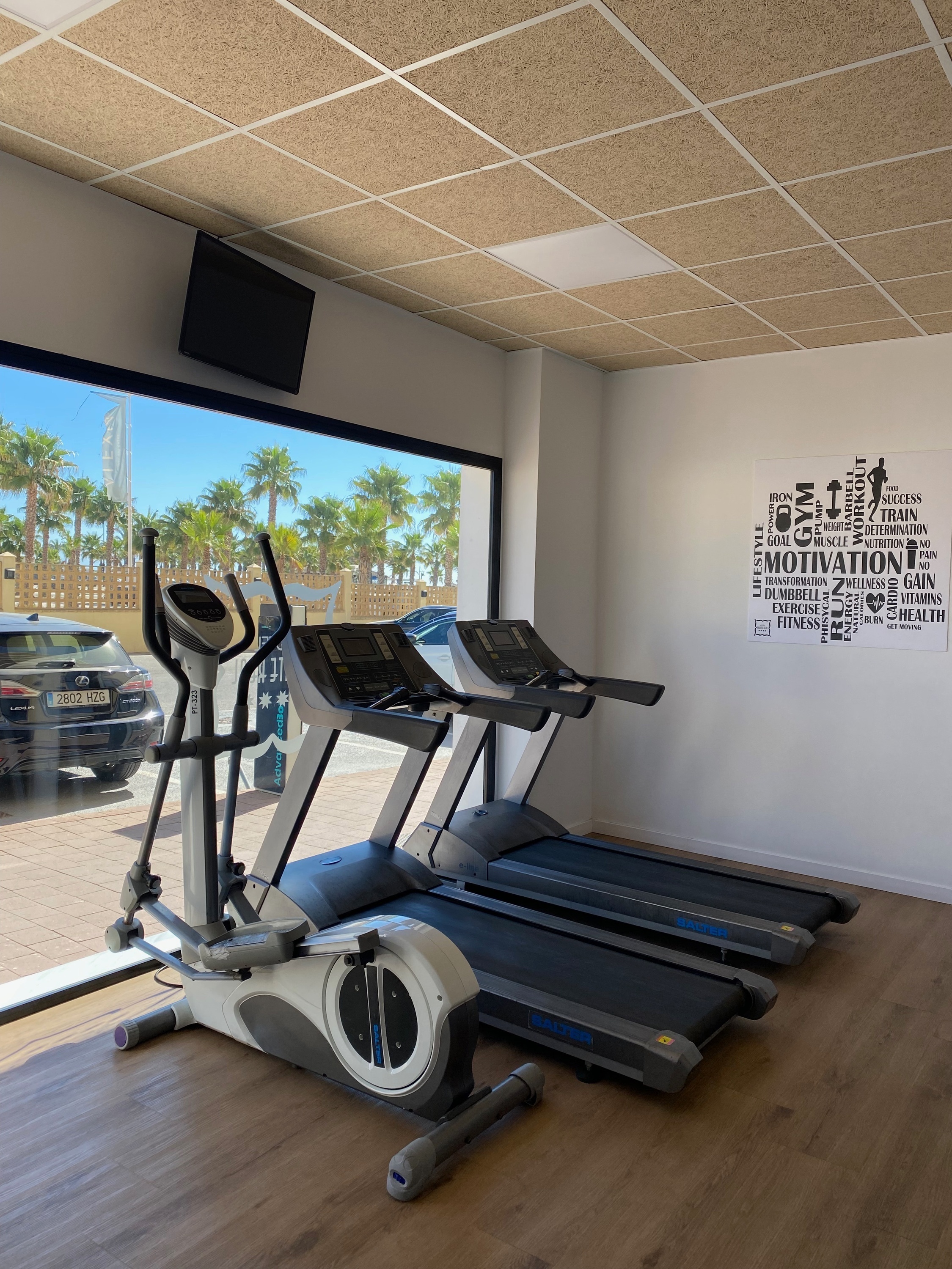 two treadmills and an elliptical are in a gym