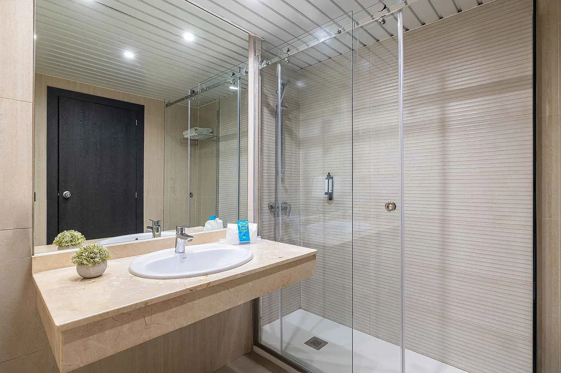 Modern bathroom at Hotel Puente Real Torremolinos with shower and sink.