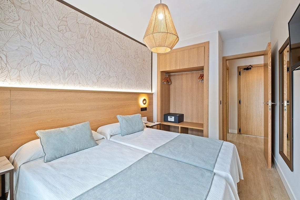 una habitación de hotel con dos camas y una ventana