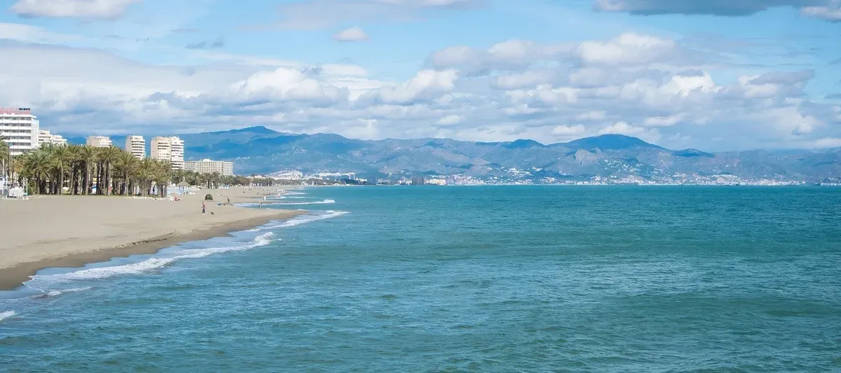 Panoramic view of the beach and sea at Hotel Puente Real **** with mountains in the background