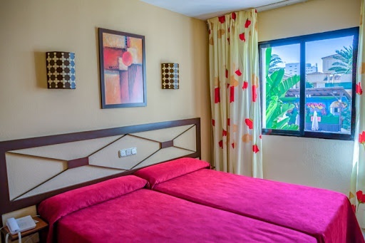 ein Hotelzimmer mit zwei Betten und einem Fenster