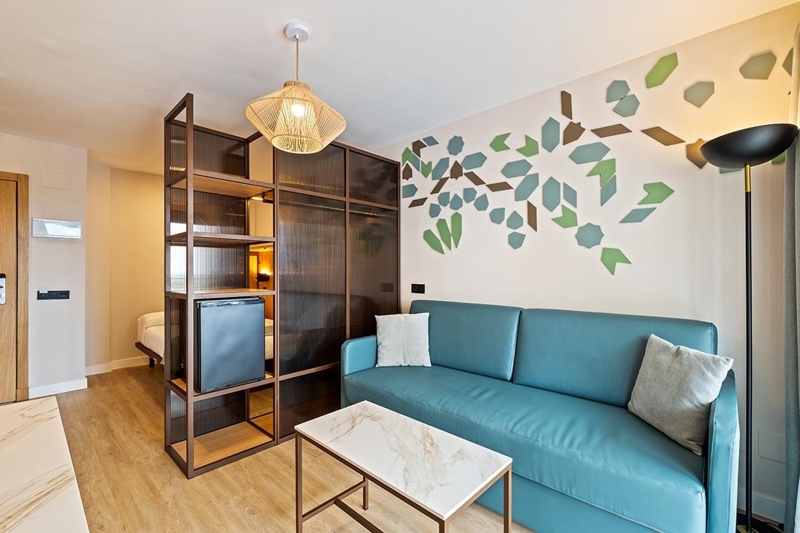 una sala de estar con un sofá azul y una mesa de mármol