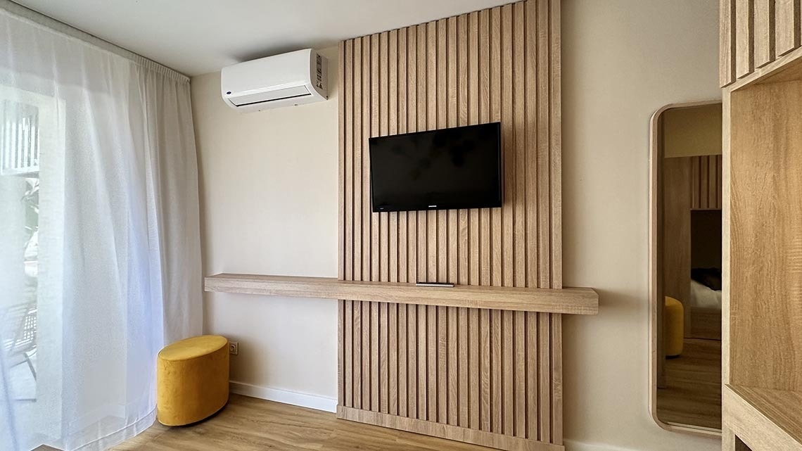une télévision samsung est accrochée à un mur en bois