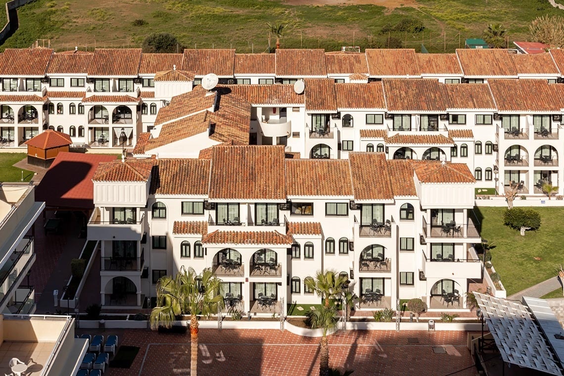 un gran edificio blanco con techos de tejas rojas y balcones