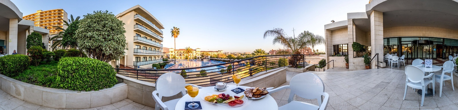 there is a table with food on it on the balcony of a hotel .