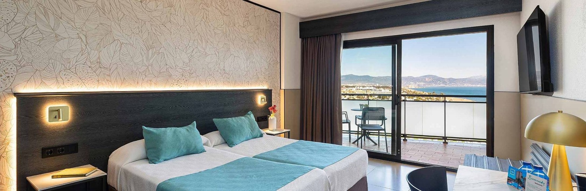 une chambre d' hôtel avec deux lits , une chaise et un balcon avec vue sur l' océan .