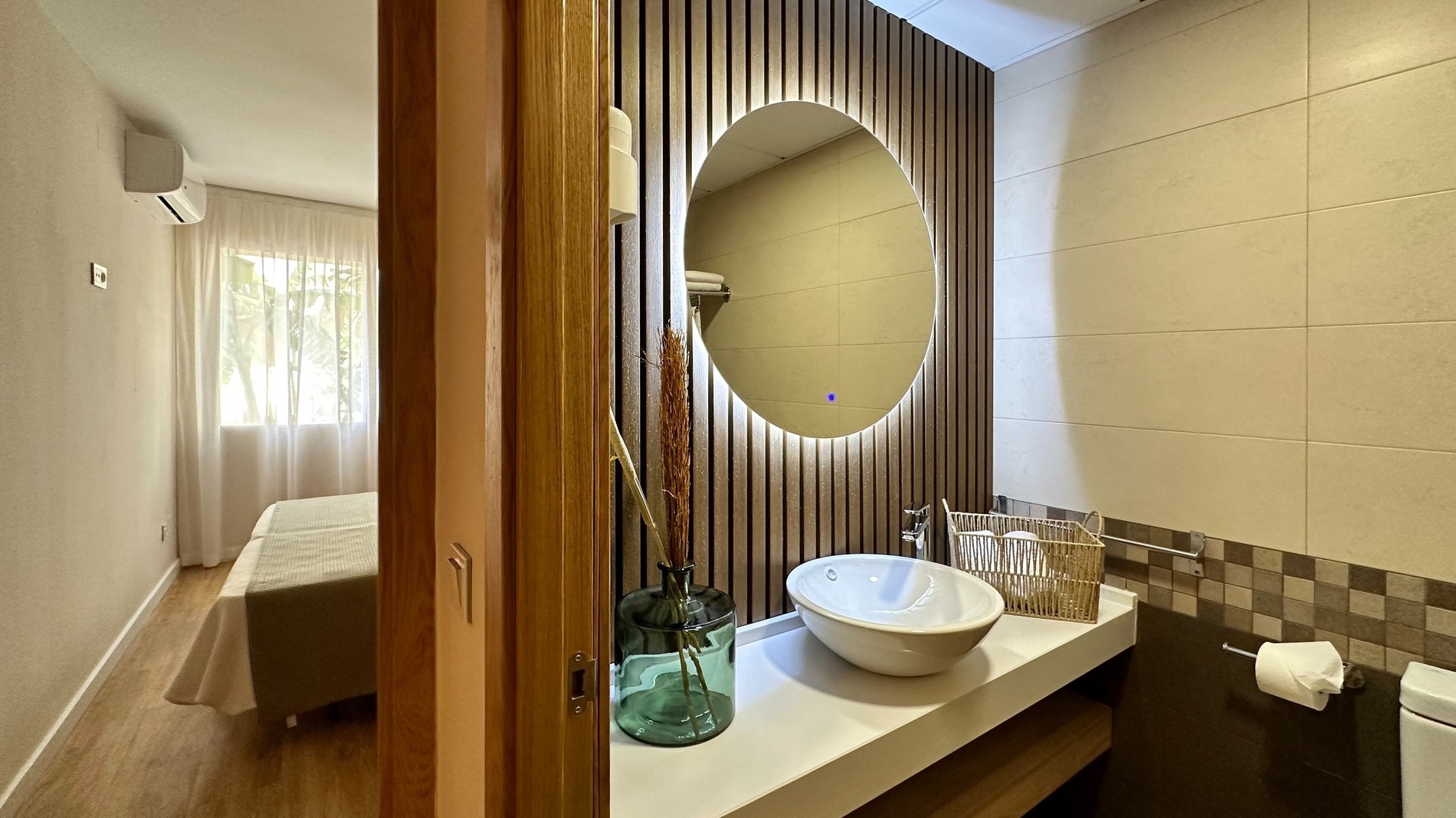 a bathroom with a round mirror and a sink