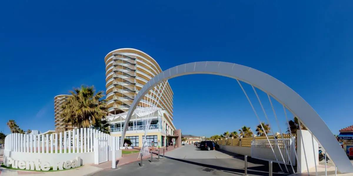 Hotel Puente Real ****: Modern beach hotel with curved architecture and palm trees.
