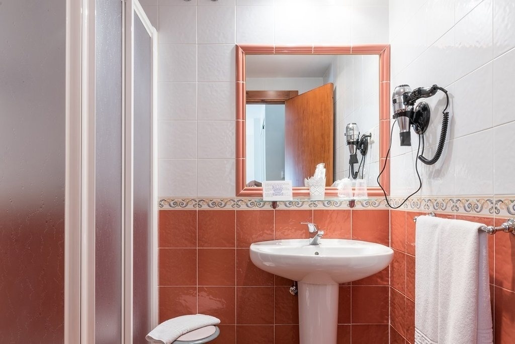 a bathroom with a sink a mirror and a hair dryer