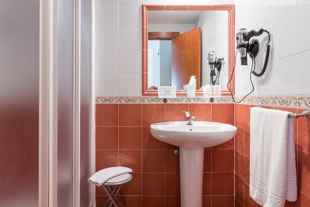 a bathroom with a sink a mirror and a hair dryer