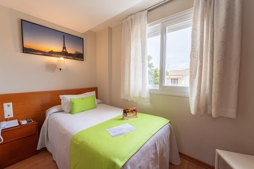 a hotel room with a picture of the eiffel tower above the bed