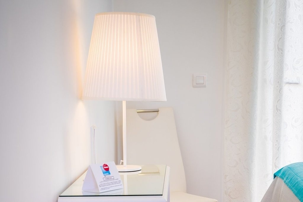 a white lamp sits on a glass table next to a sign that says ' a ' on it