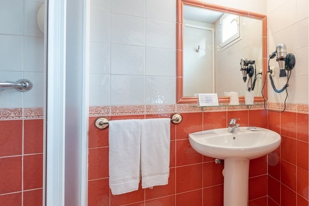 a bathroom with red and white tiles and a sink