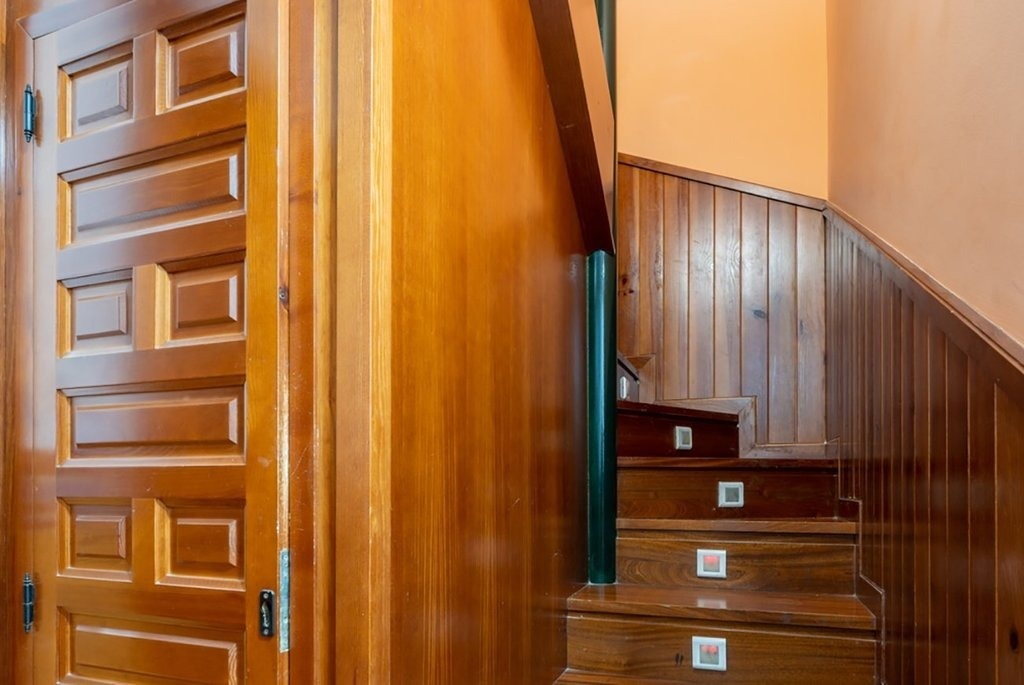 una escalera de madera en una casa con una puerta de madera
