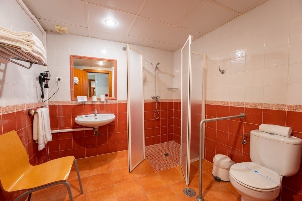 a bathroom with red and white tiles and a toilet