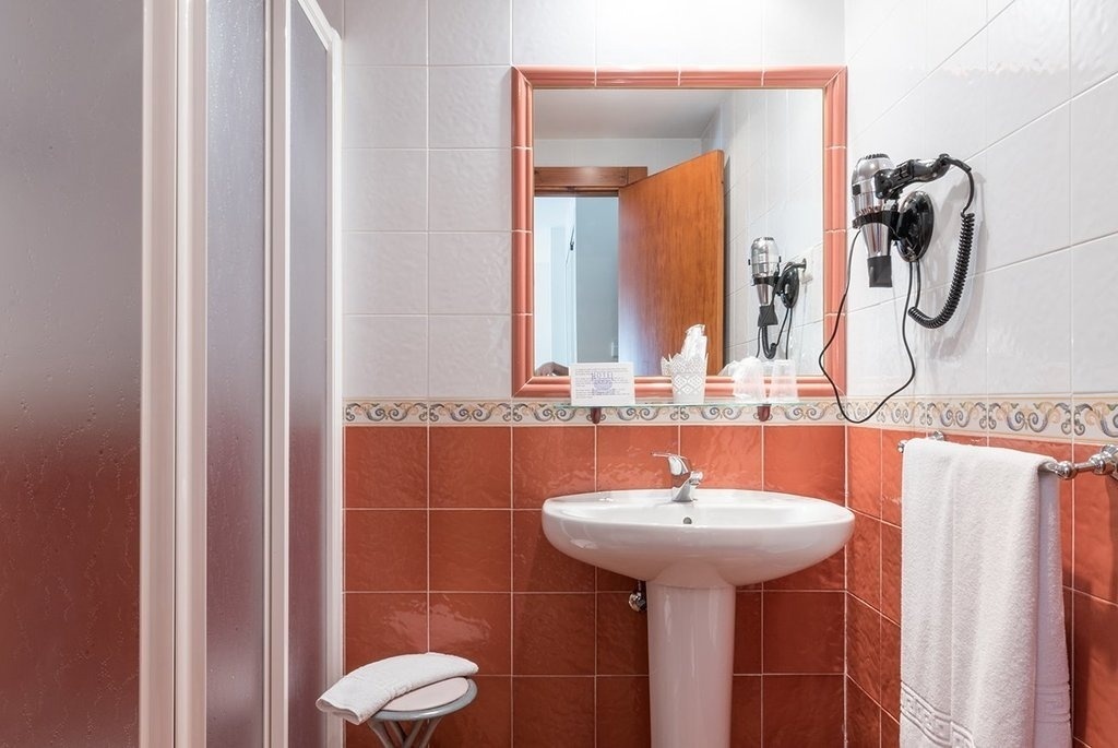 un baño con un lavabo y un secador de pelo