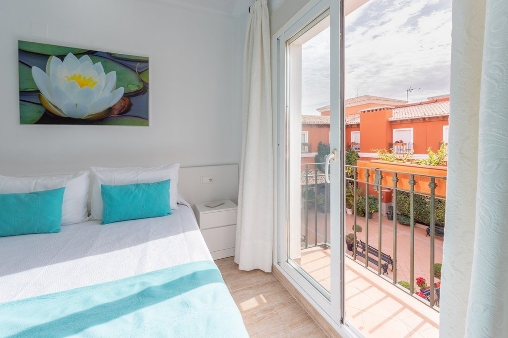 a bedroom with a painting of a flower on the wall