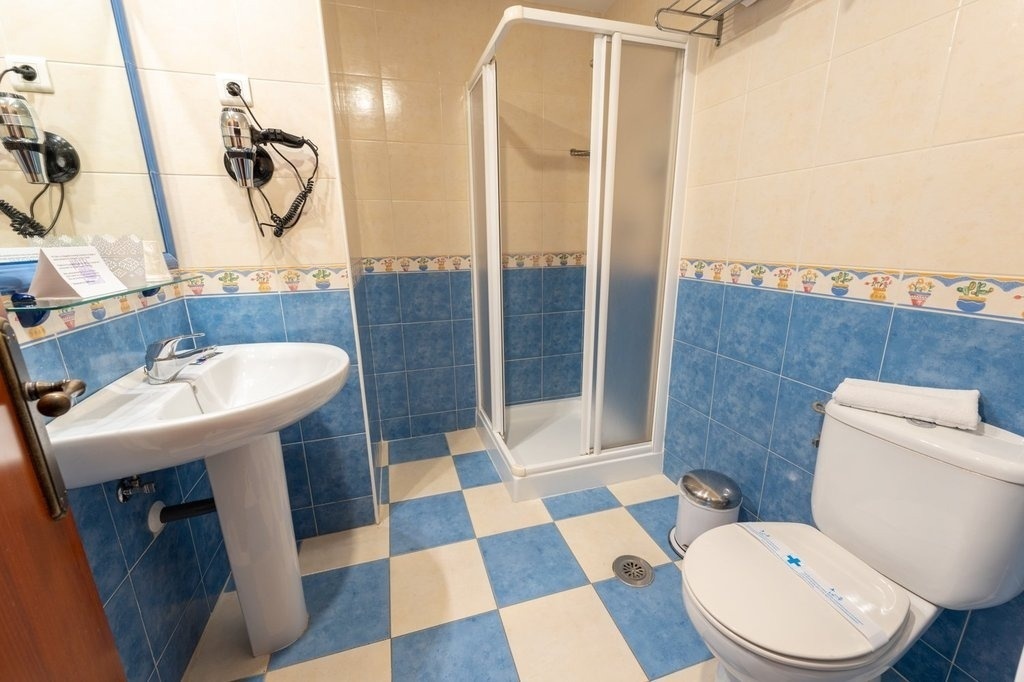 a bathroom with blue and white tiles and a toilet