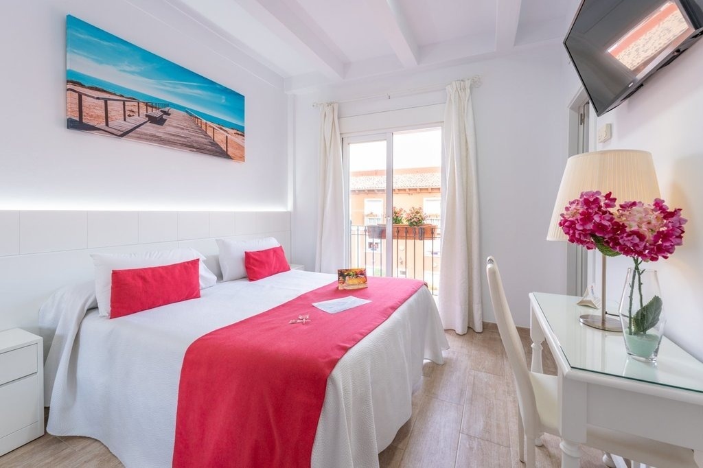 una habitación con una cama y una pintura en la pared