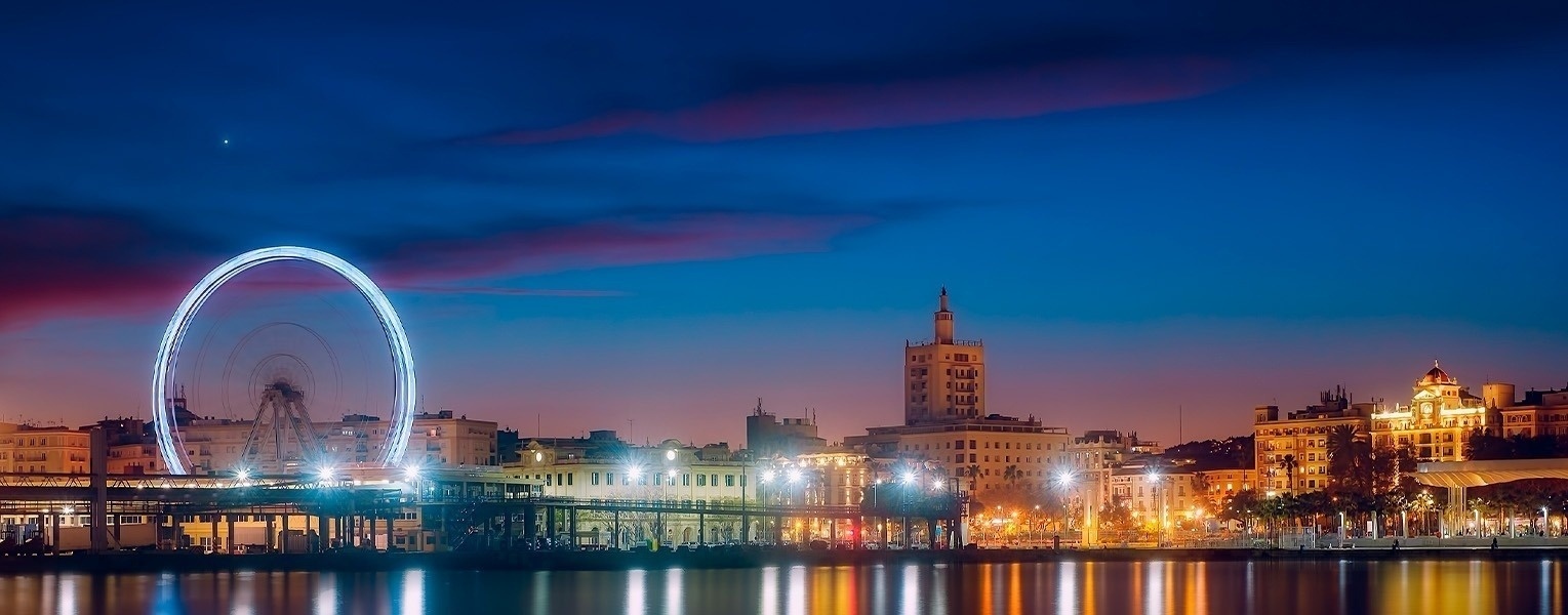 a sunset over a city with a clock tower in the foreground