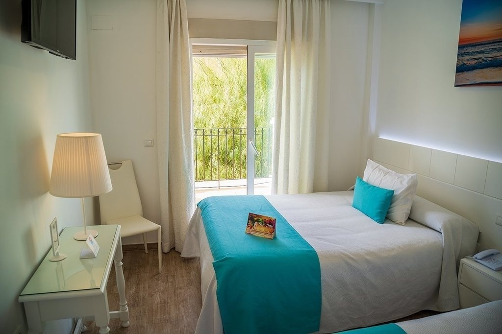 a hotel room with a blue blanket on the bed