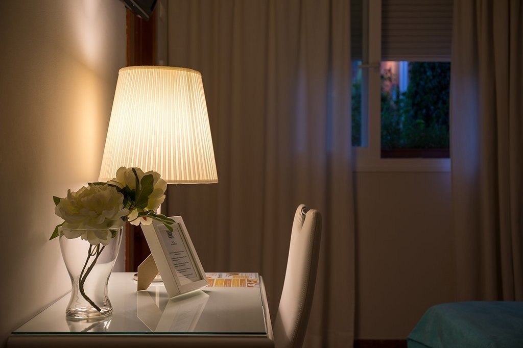 una mesa con una lámpara y un jarrón de flores
