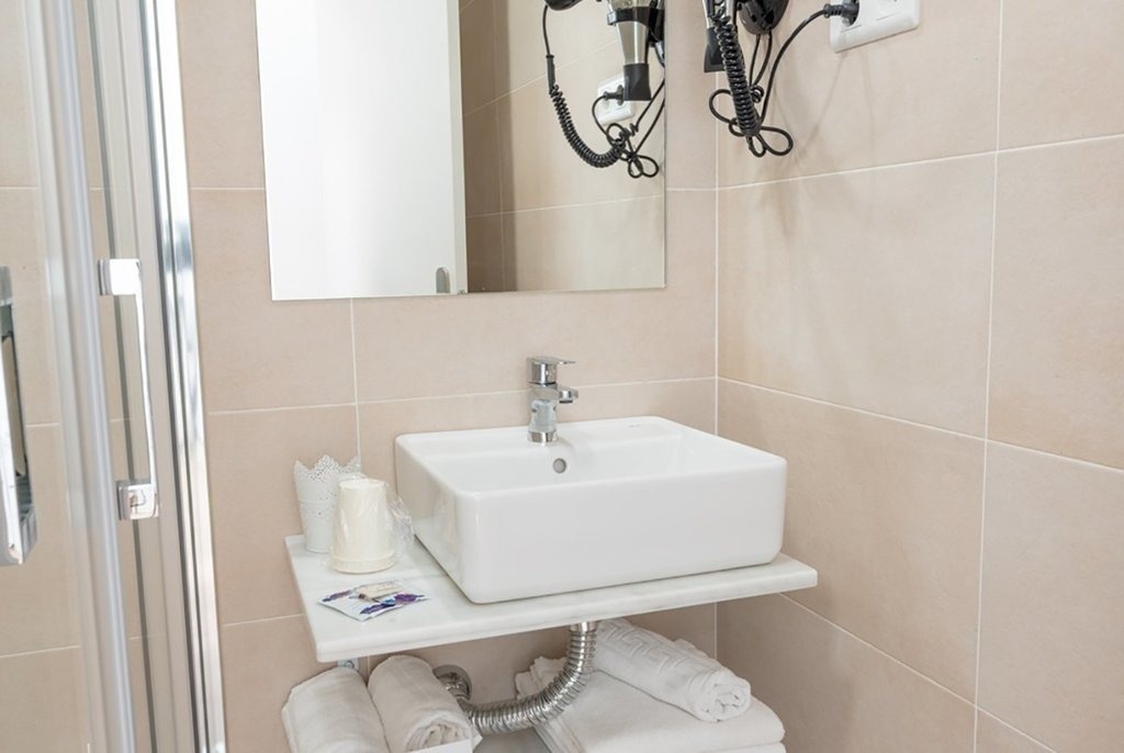 a bathroom with a sink a mirror and a hair dryer