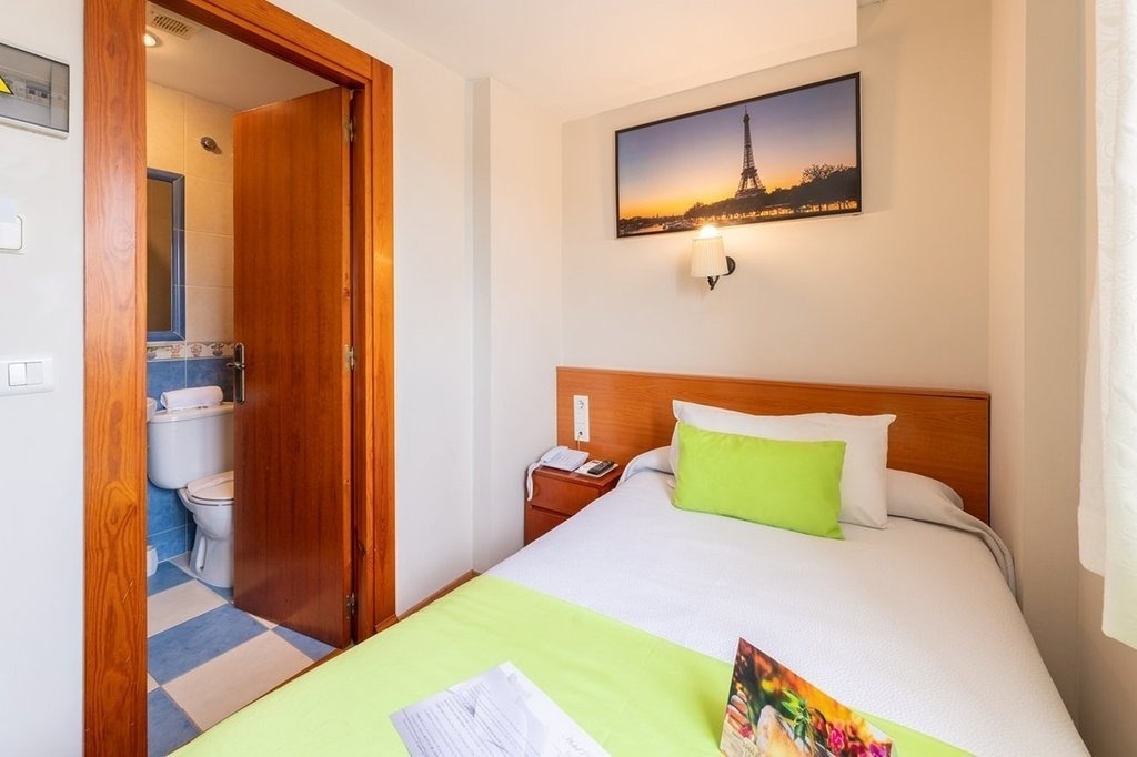 a bedroom with a picture of the eiffel tower above the bed