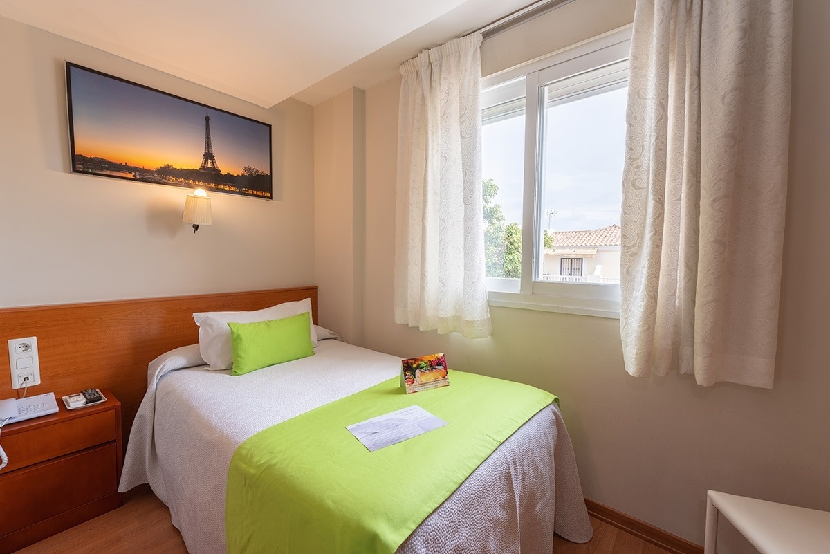 a hotel room with a picture of the eiffel tower above the bed