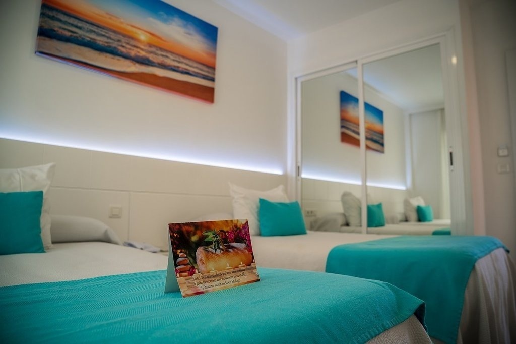 a hotel room with two beds and a sign on the bed