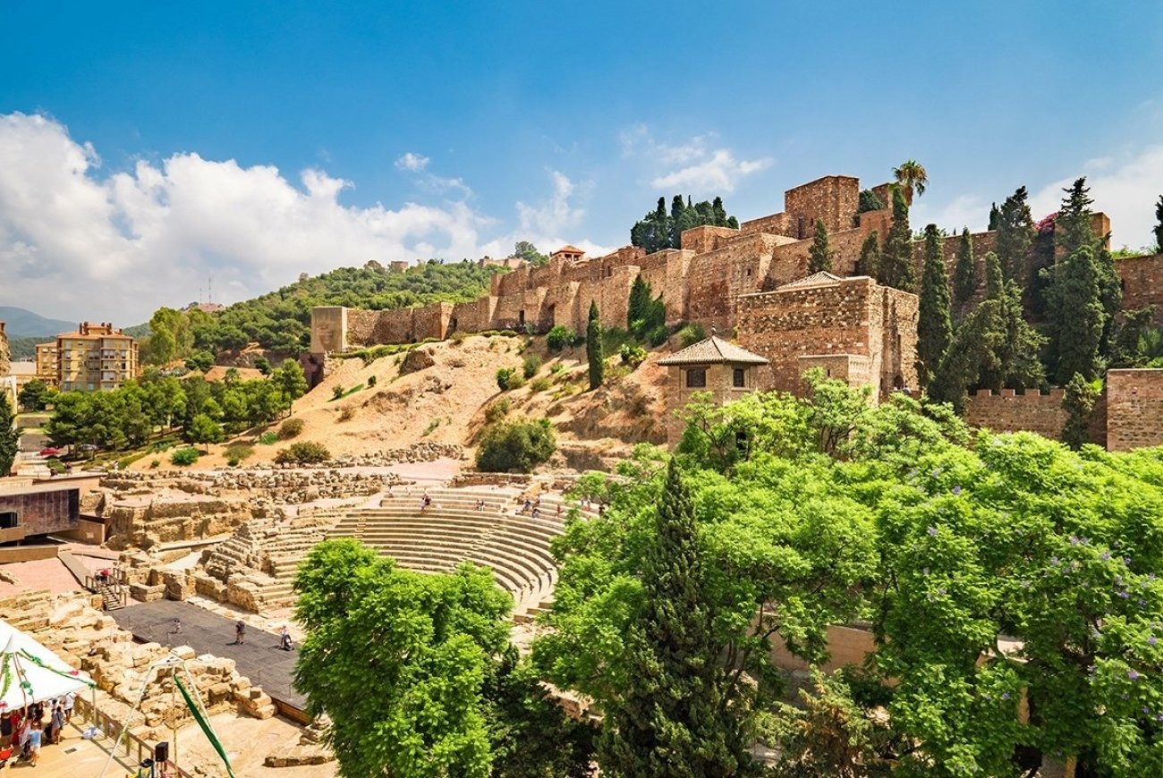 a large stone wall is surrounded by trees and buildings