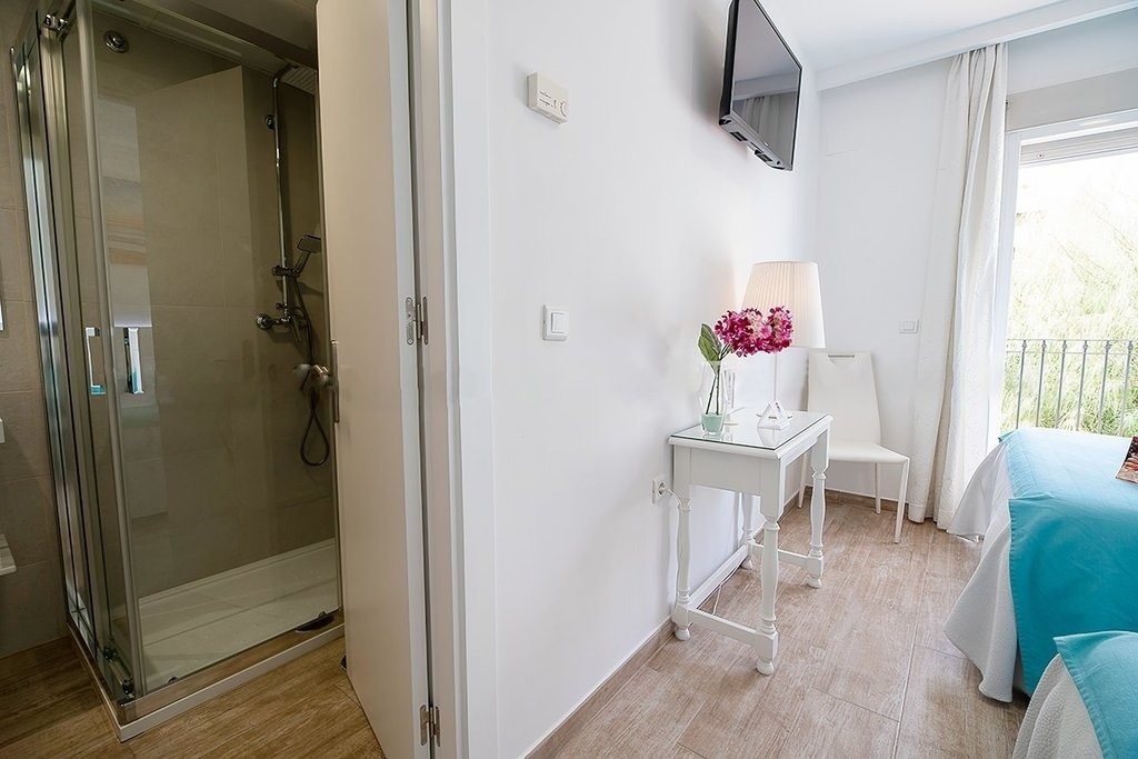 a bathroom with a walk in shower and a table with flowers on it